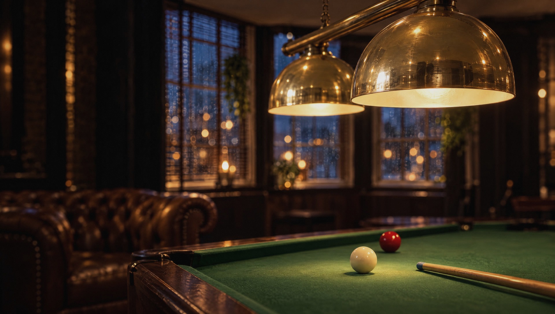 Brass pendant lamps glowing over the green baize of the pool table